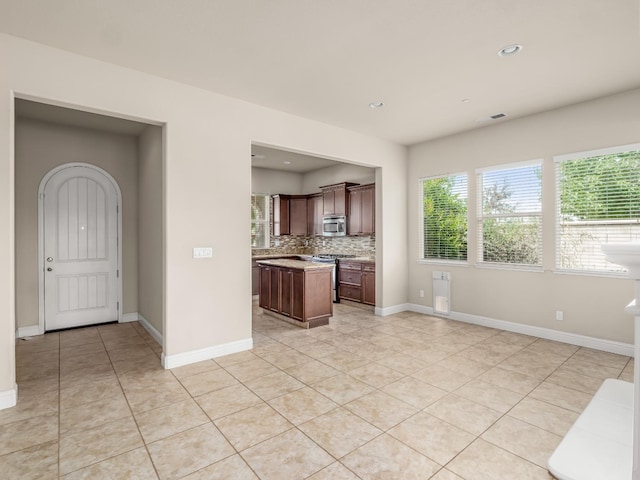 7993 N Justin Ave, Fresno, CA 93720 - kitchen featuring decorative backsplash, a center island, light countertops, appliances with stainless steel finishes, and light tile patterned floors