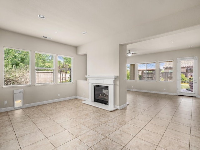7993 N Justin Ave, Fresno, CA 93720 - unfurnished living room featuring visible vents, a glass covered fireplace, baseboards, ceiling fan, and light tile patterned floors