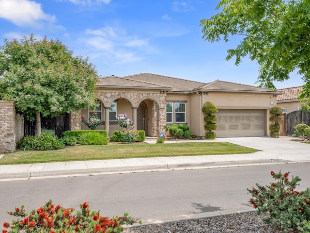 7993 N Justin Ave, Fresno, CA 93720 - view of front of home with fence, an attached garage, a tile roof, stucco siding, and driveway
