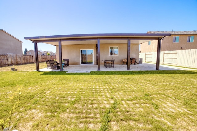 rear view of property with a fenced backyard, a patio area, stucco siding, and a yard