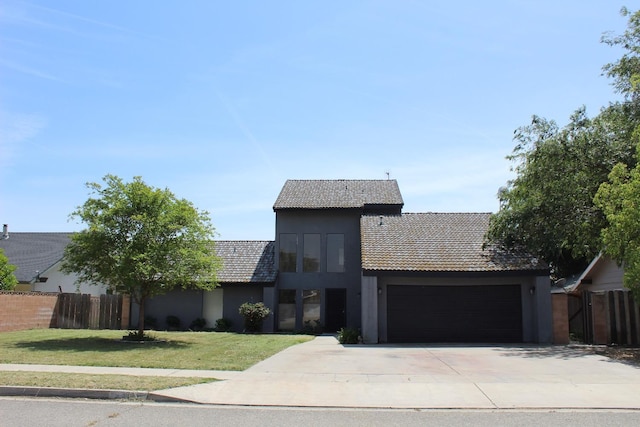 2791 W Kofoid Ave, Caruthers, CA 93609 - view of front of house featuring fence, a front yard, stucco siding, concrete driveway, and an attached garage