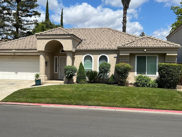 9552 N Whitehouse Dr, Fresno, CA 93720 - mediterranean / spanish home with a tile roof, concrete driveway, a garage, and a front lawn