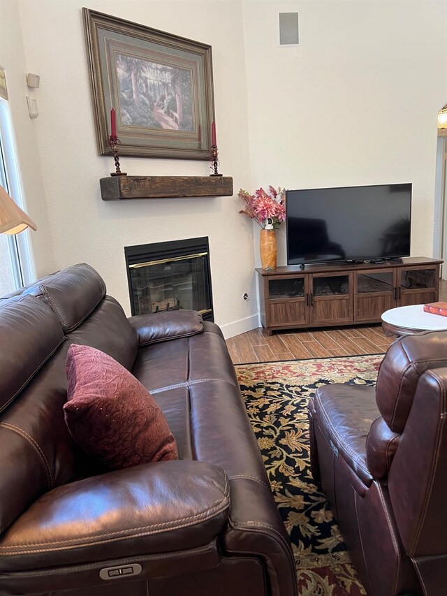 9552 N Whitehouse Dr, Fresno, CA 93720 - living area featuring wood finished floors, a glass covered fireplace, and baseboards