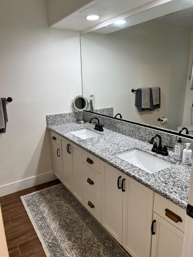 9552 N Whitehouse Dr, Fresno, CA 93720 - full bathroom featuring double vanity, baseboards, wood finished floors, and toilet
