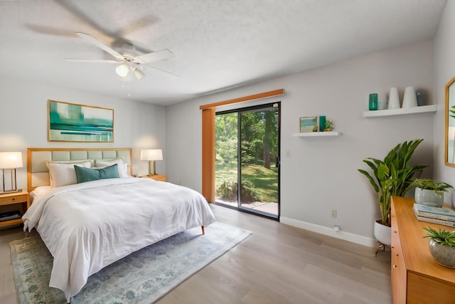 bedroom with a ceiling fan, access to outside, wood finished floors, and baseboards
