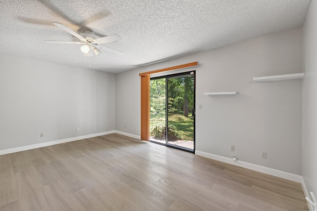 empty room with a textured ceiling, baseboards, wood finished floors, and a ceiling fan