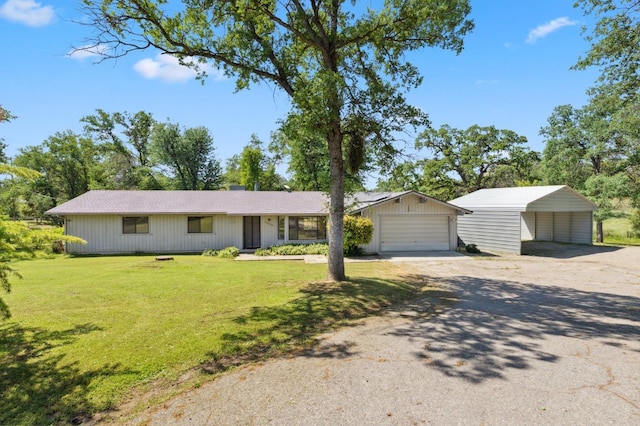 single story home featuring a detached garage, dirt driveway, and a front yard