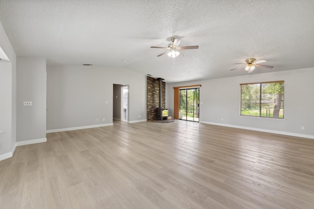 33563 Frazier Rd, Auberry, CA 93602 - unfurnished living room featuring a ceiling fan, a wood stove, a textured ceiling, light wood-style flooring, and vaulted ceiling