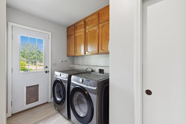 laundry area featuring cabinet space, light wood finished floors, and washer and dryer