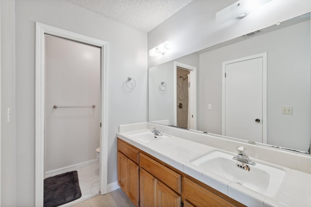 full bathroom featuring a sink, toilet, baseboards, and marble finish floor