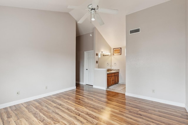 interior space with visible vents, baseboards, ceiling fan, high vaulted ceiling, and light wood finished floors