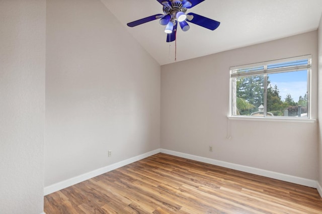 empty room with baseboards, ceiling fan, vaulted ceiling, and wood finished floors