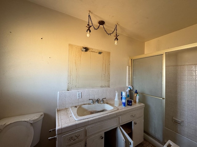 bathroom featuring vanity, backsplash, walk in shower, and toilet