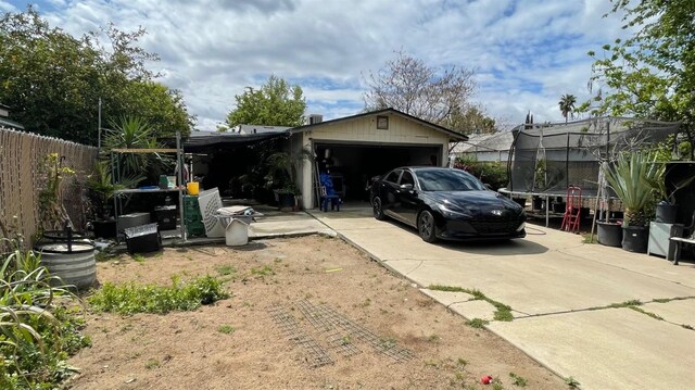 3535 E Grant Ave, Fresno, CA 93702 - garage featuring a trampoline and concrete driveway