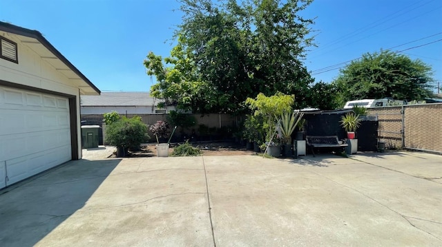 exterior space with a garage, a fenced backyard, and concrete driveway