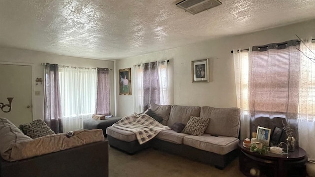 carpeted living area featuring visible vents and a textured ceiling