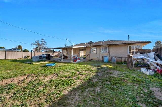 4185 E Turner Ave, Fresno, CA 93702 - back of property with a lawn, a fenced backyard, a patio area, and stucco siding