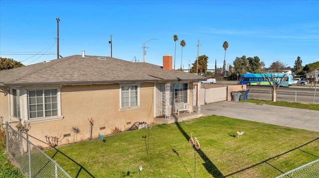 4185 E Turner Ave, Fresno, CA 93702 - back of property featuring fence, stucco siding, a lawn, and a chimney