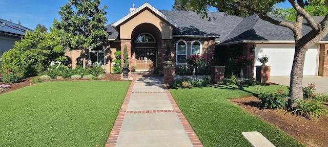 view of front facade featuring brick siding, a garage, driveway, and a front yard
