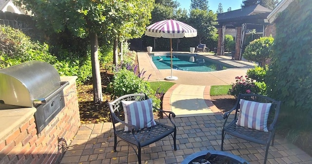 view of pool featuring fence, exterior kitchen, grilling area, a fenced in pool, and a patio
