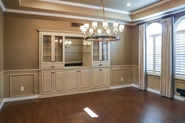 unfurnished dining area featuring visible vents, a notable chandelier, a healthy amount of sunlight, and a raised ceiling