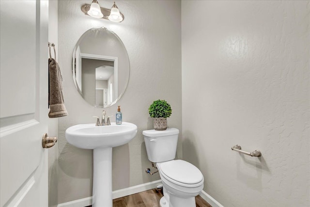 1938 W Van Gogh St, Hanford, CA 93230 - half bath featuring a sink, baseboards, toilet, and wood finished floors