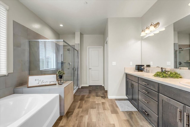 1938 W Van Gogh St, Hanford, CA 93230 - bathroom featuring double vanity, a bath, a shower stall, wood finished floors, and a sink