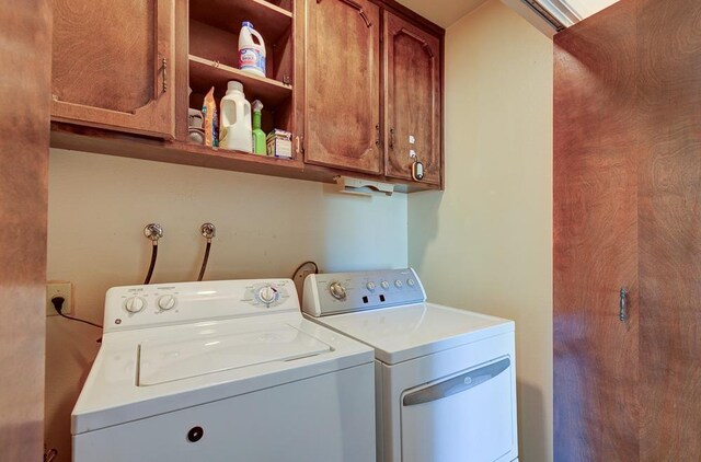 clothes washing area with cabinet space and washing machine and dryer