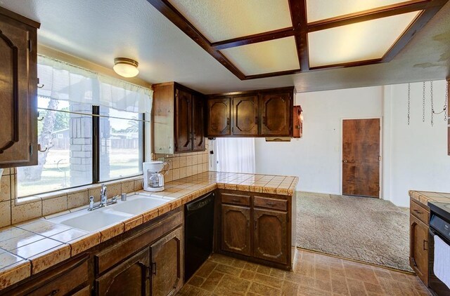 kitchen with backsplash, dishwasher, a sink, a peninsula, and tile counters