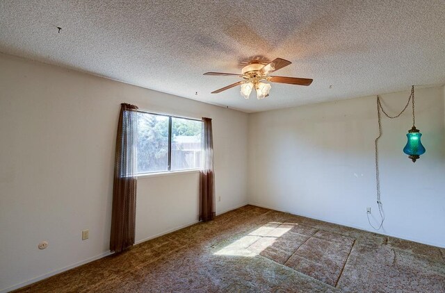 carpeted empty room featuring a ceiling fan and a textured ceiling