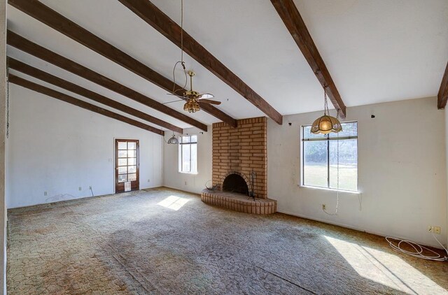 unfurnished living room with carpet floors, vaulted ceiling with beams, a ceiling fan, and a brick fireplace