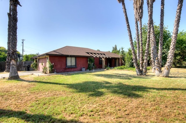 ranch-style home with concrete driveway, fence, a front yard, and a garage