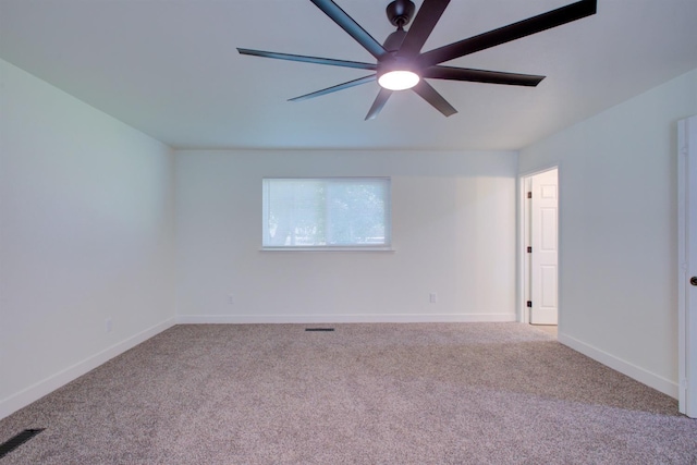 carpeted empty room with visible vents, a ceiling fan, and baseboards
