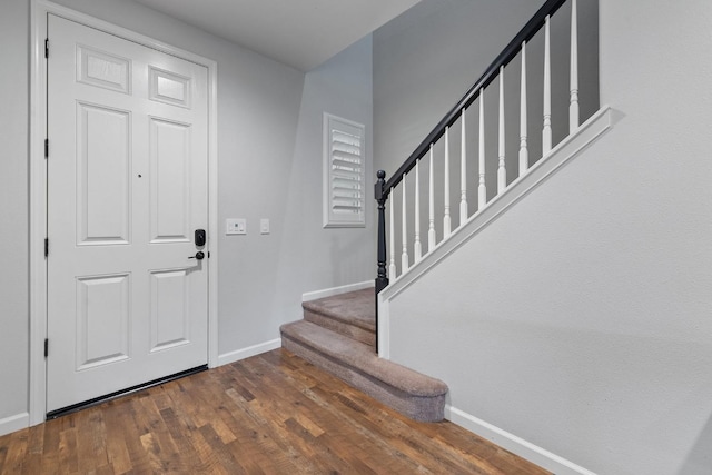 entrance foyer featuring baseboards, stairs, and wood finished floors