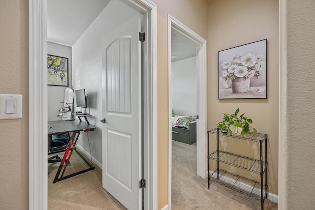 corridor with baseboards and carpet flooring