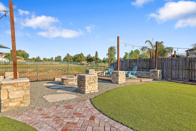 view of yard featuring a fenced backyard, a fire pit, and a patio area