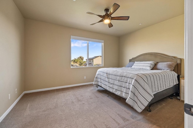 carpeted bedroom featuring baseboards and a ceiling fan