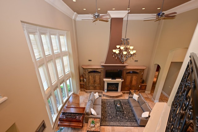 living room with ceiling fan with notable chandelier and a towering ceiling
