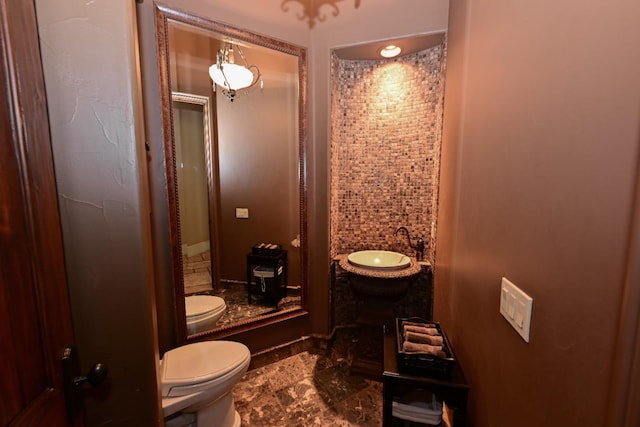 bathroom with a sink, a stall shower, and toilet