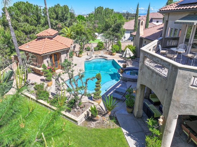 view of swimming pool featuring a fenced backyard, a pool with connected hot tub, and a patio area
