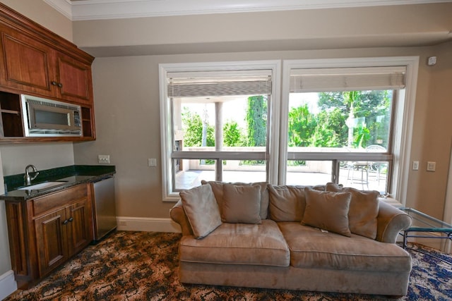 living area with crown molding and baseboards