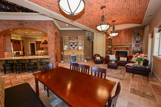 dining area with visible vents, built in shelves, stone tile flooring, lofted ceiling, and recessed lighting