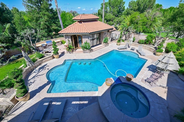 view of swimming pool featuring fence, a patio, an in ground hot tub, and an outbuilding