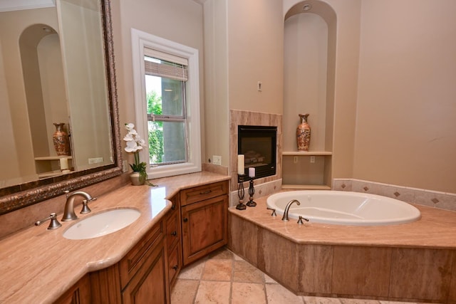 bathroom with vanity, a bath, and stone tile flooring