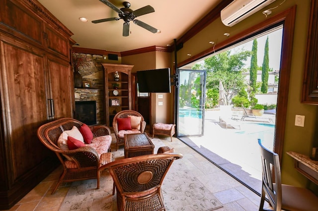 sitting room featuring stone finish floor, ceiling fan, crown molding, a fireplace, and an AC wall unit