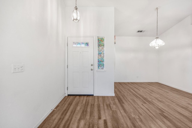 entrance foyer featuring visible vents, baseboards, and an inviting chandelier