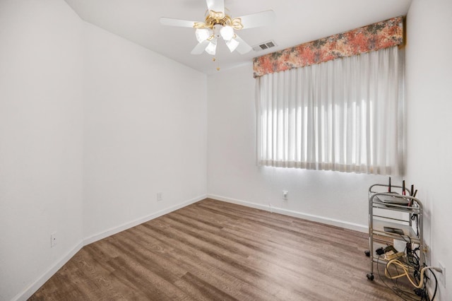 empty room featuring visible vents, baseboards, ceiling fan, and wood finished floors