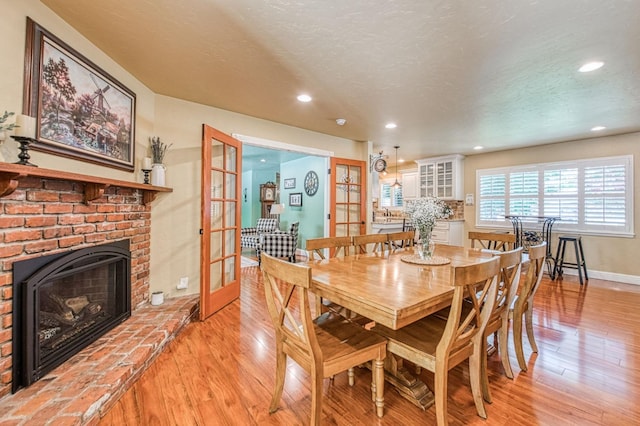 dining space featuring recessed lighting, baseboards, french doors, and light wood finished floors