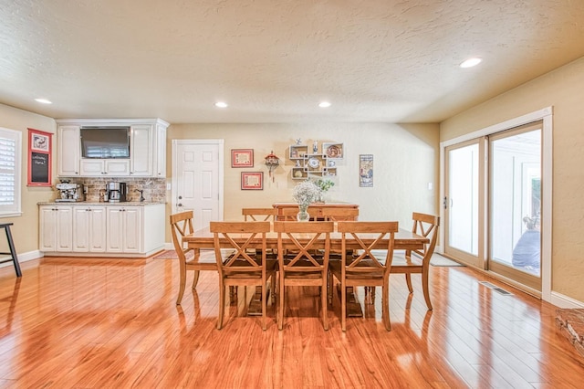 dining room featuring visible vents, baseboards, light wood-type flooring, recessed lighting, and a textured ceiling