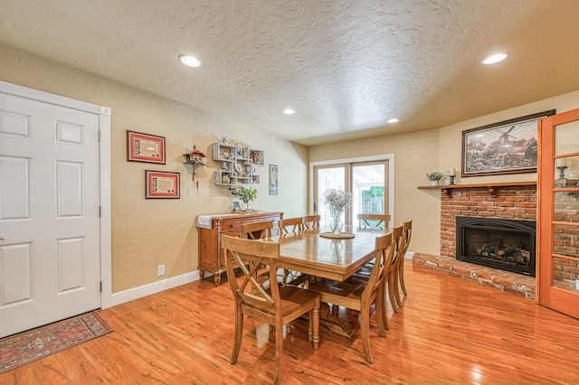 dining space featuring recessed lighting, light wood-type flooring, and a textured ceiling